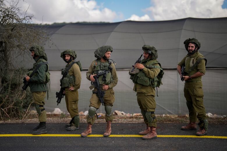 Five men in military gear lined up in a row