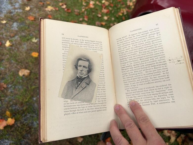 A person holds a book open.