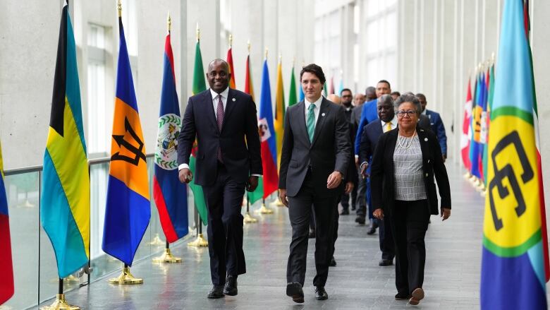 Dominica Prime Minister Roosevelt Skerrit, left to right, Prime Minister Justin Trudeau and CARICOM Secretary General Carla Barnett arrive at the family photo at the Canada-CARICOM summit in Ottawa on Wednesday, Oct.18, 2023. THE CANADIAN PRESS/Sean Kilpatrick