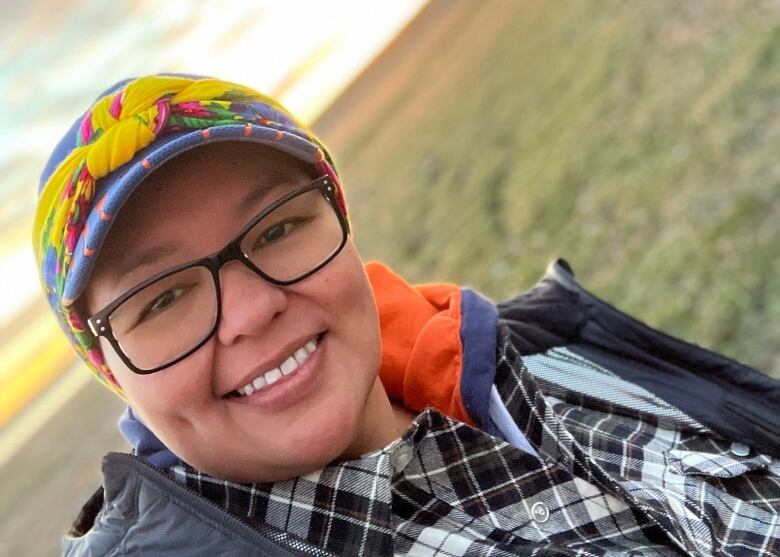 Stephanie Taptuna poses for a close up photo with the sunset in the background