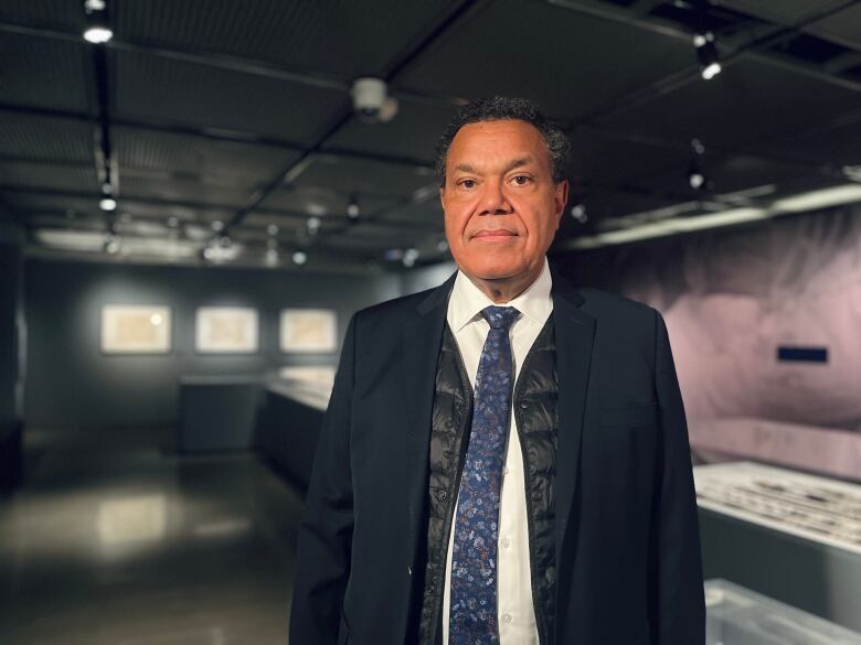 A man stands in the middle of an exhibition space.