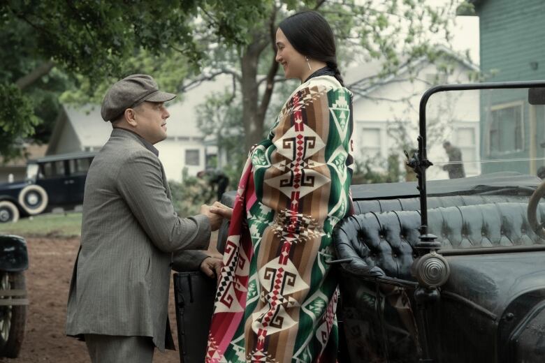 Ernest the driver offers Mollie, a wealthy Osage woman a ride, in an opening scene from Killers of the Flower Moon starring Leonardo DiCaprio and Lily Gladstone. 