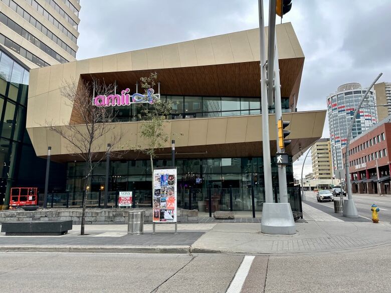 A two-storey office building on a downtown street corner, with other buildings in the background.