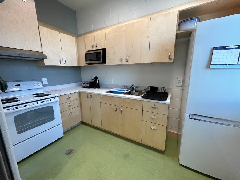 Standard kitchen with cupboards, sink, stove and fridge. 