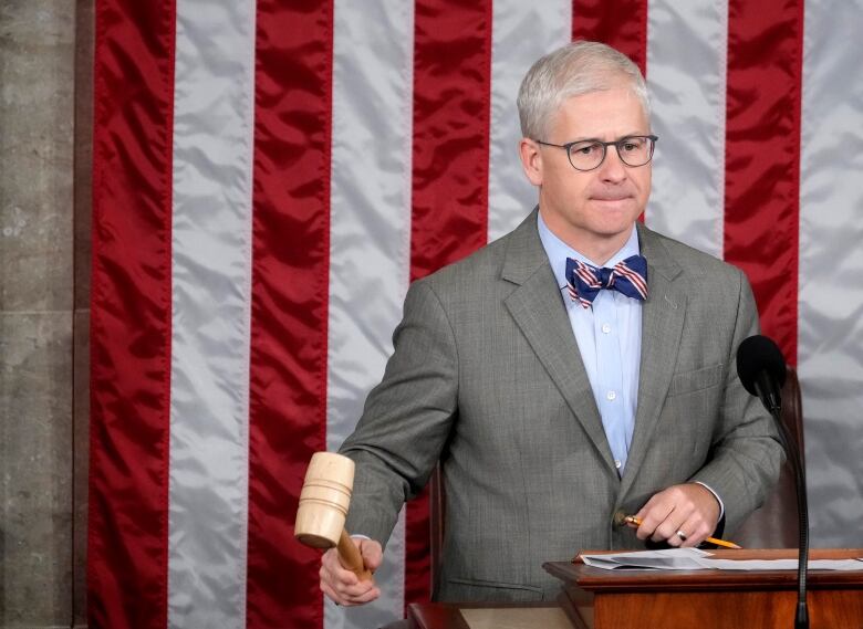 A person holds up a gavel.