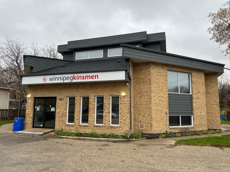 A two-storey brick building bears a sign saying 