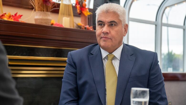 A man wearing a suit sits at a table.