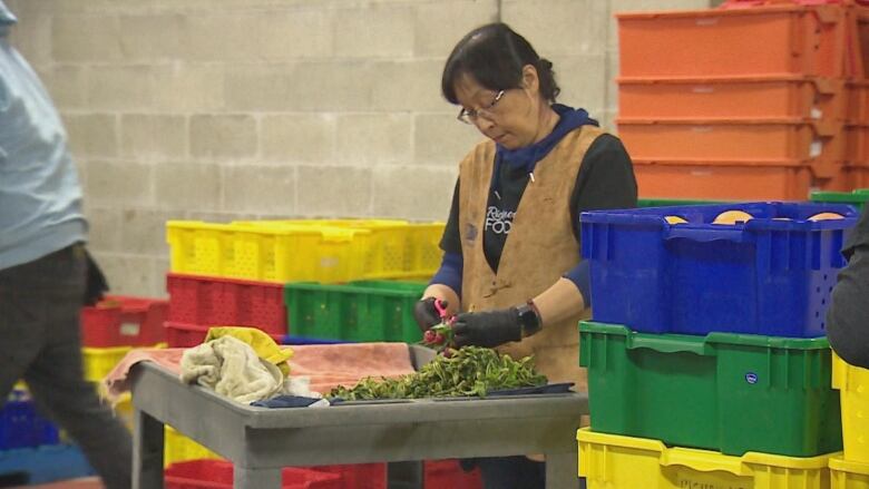 A woman cuts produce. 