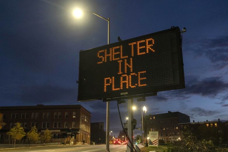 A road sign reads: shelter in place, following a mass shooting at a restaurant and bowling alley in Lewiston, Maine.