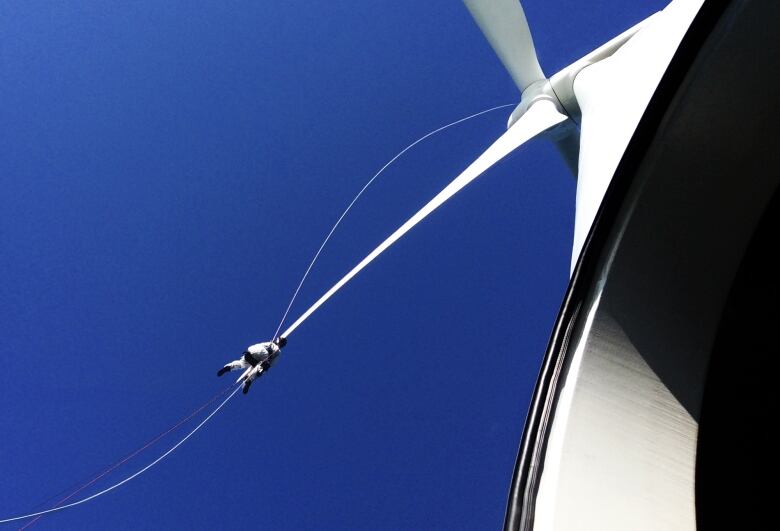 A technician fixes a wind turbine.