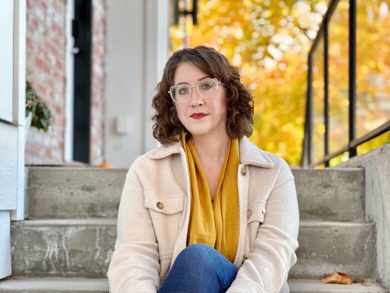 A woman sits on a set of steps.