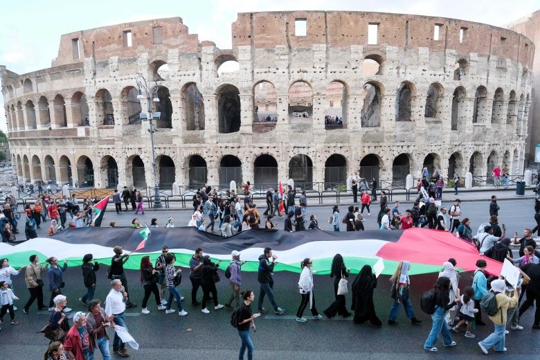 People march past the ancient Colosseum during a pro-Palestinian demonstration in Rome.