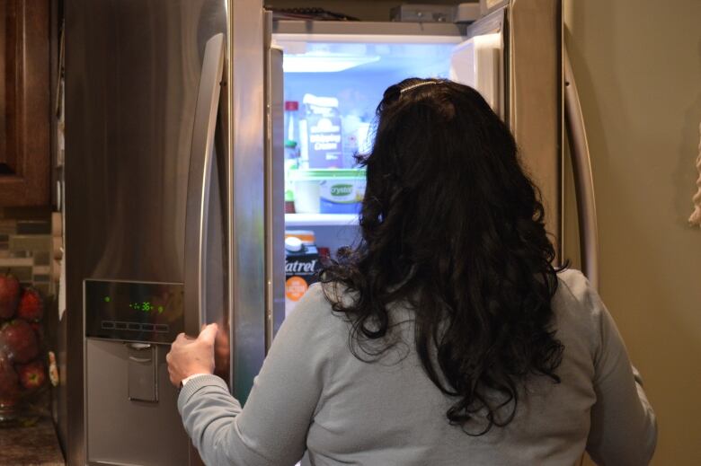 A woman looks into a fridge