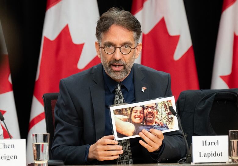 Harel Lapidot holds a picture of a relative who was killed by Hamas in its Oct. 7 attack on Israel.