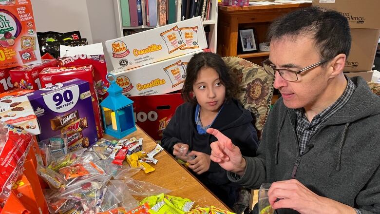 Pierre Anthian and daughter Eve packing Halloween candy. 