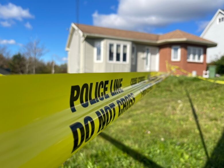 Police tape reading 'police line' in front of a house. 