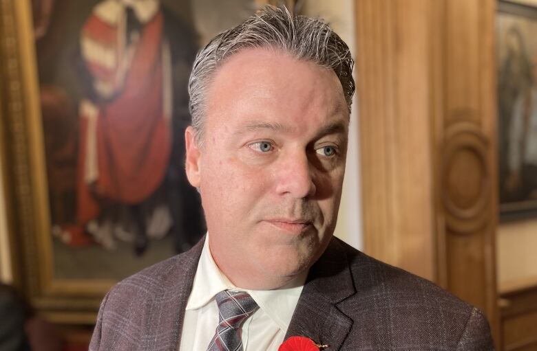 A man in a suit and tie faces away from the camera.