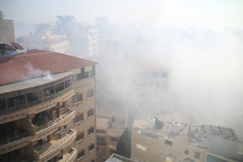 White smokes rises around buildings.