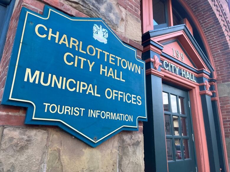 A brick building with a sign on the city that reads 'Charlottetown City Hall Municipal Services.'