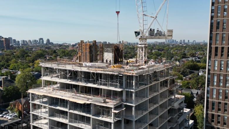 A condo construction site, with workers spotted on site.