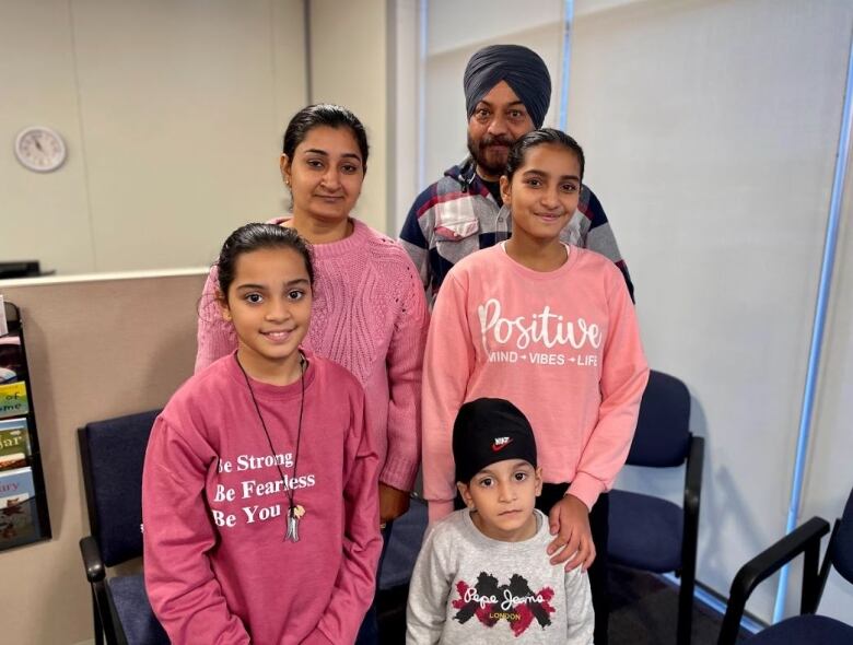 Mother, father and three children pose for a picture.