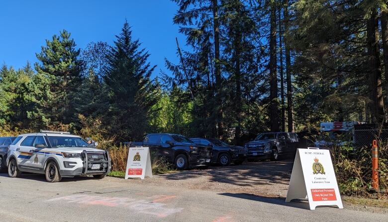 police vehicles parked near a wooded driveway