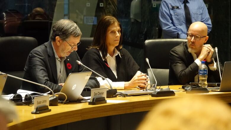 People sit at a public meeting.