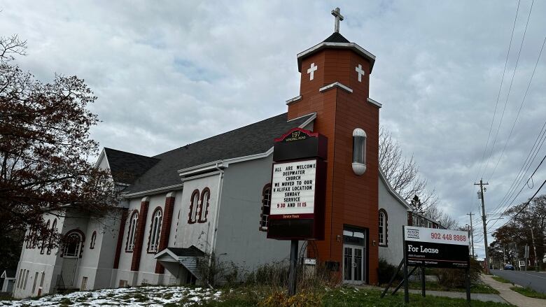 A white Catholic church with a brick steeple.