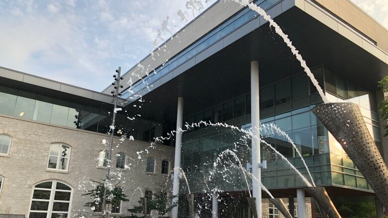 Photo of grey building with fountains in front