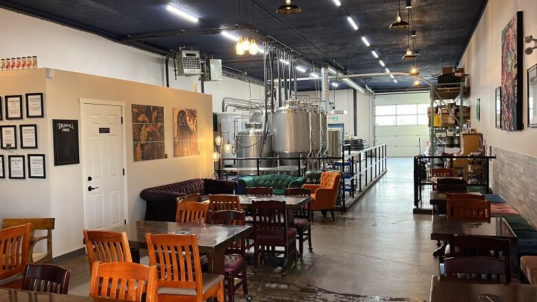 A small tasting room with brewing equipment in the background.