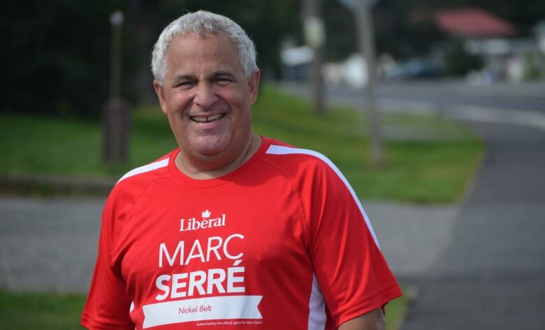 A man wearing a red Marc Serr shirt