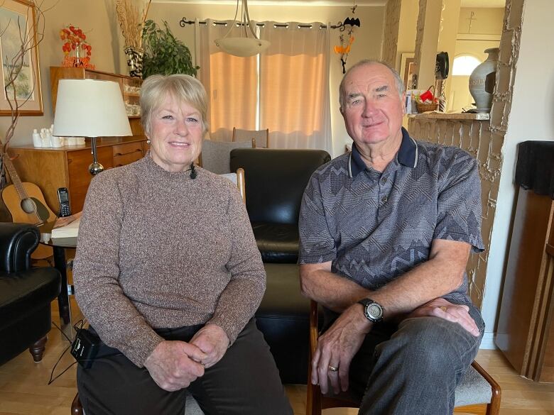 An elderly man and women sit on a chair 