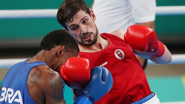 Canadian men's boxer delivers upper-cut to opponent during match at Pan Am Games in Santiago, Chile.