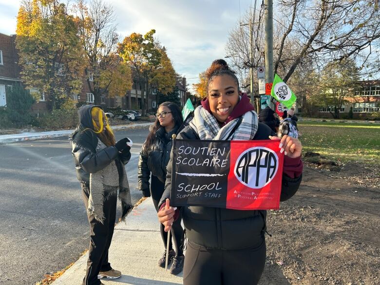 A woman holds a sign that reads 