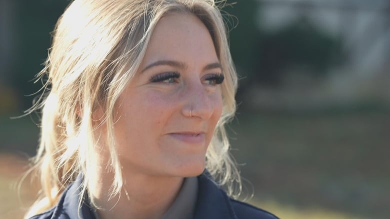 A blonde woman with a nose ring is pictured in profile.