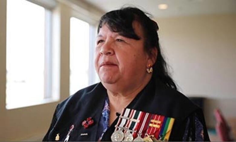 An Indigenous woman in uniform with military medals.