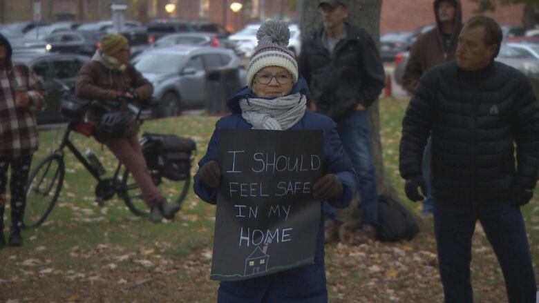 A woman holding a sign that says: 