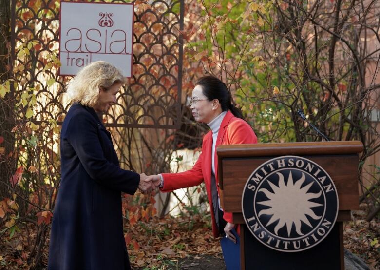 Two women shake hands