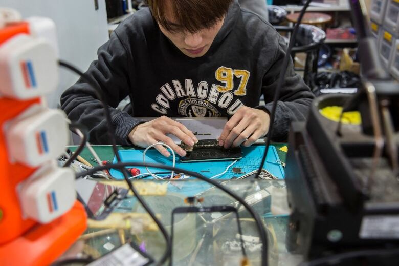 A worker fixes a mobile phone