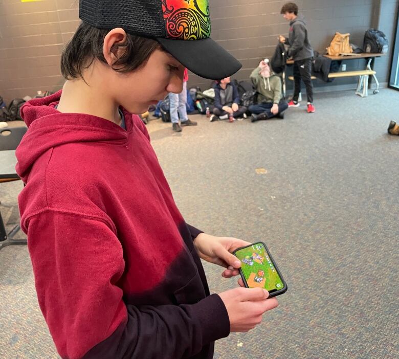 A teenager staring at a game on their phone.