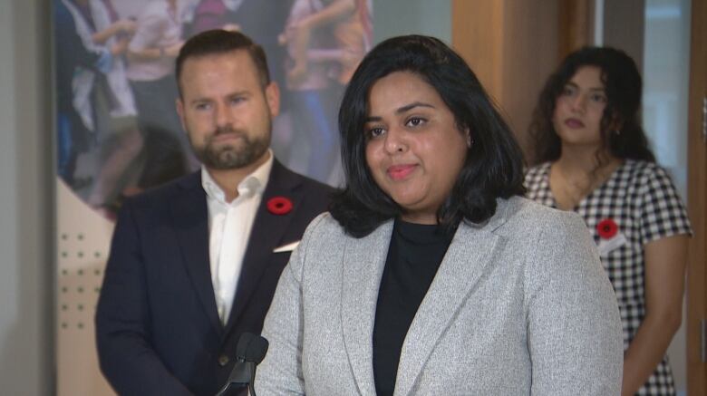 Shanika Niwanthi, a newcomer to Canada in 2021, middle, speaks to reporters at a news conference on Thursday about a plan by the province to ban employers from requiring Canadian work experience in job postings or application forms.