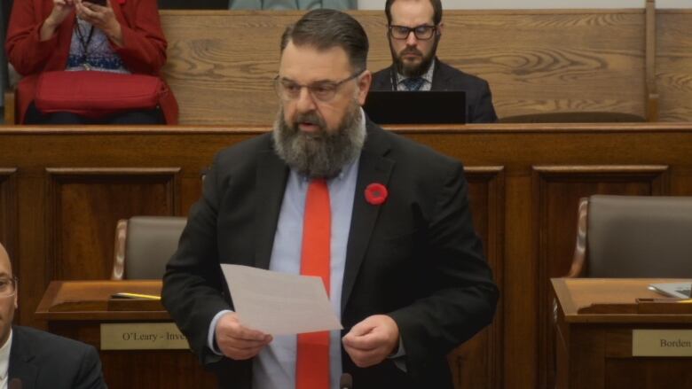 An MLA stands in the PEI legislature making a statement to government.