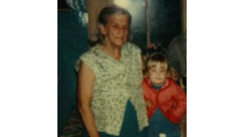 An old photo of an older woman next to a young child,