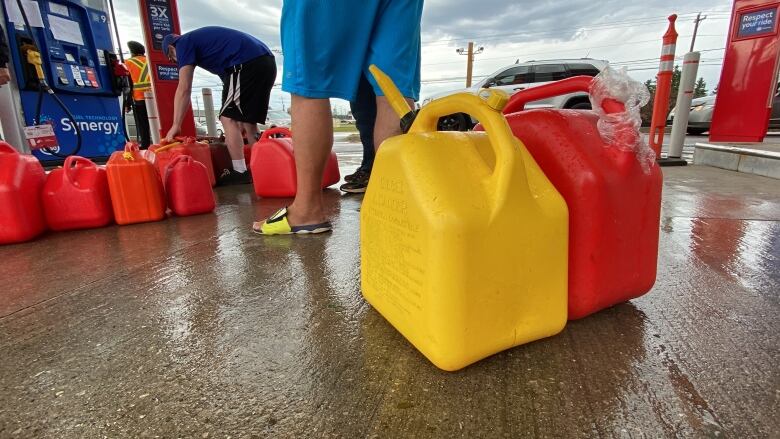 a man stands at a gas station waiting to fill his jerry cans following post-tropical storm Fiona. 