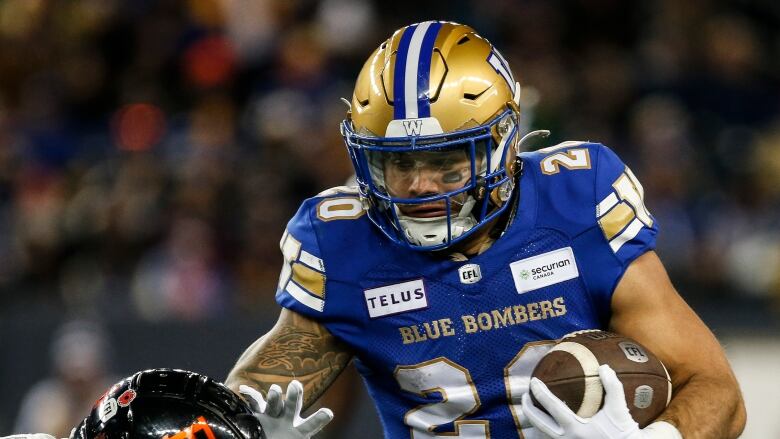 Winnipeg Blue Bombers' Brady Oliveira runs for the first down against B.C. Lions in Winnipeg Saturday.   