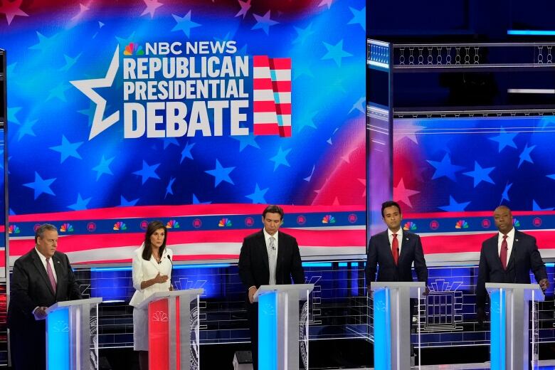 Some candidates for the Republican presidential nominee stand behind podiums during a debate.