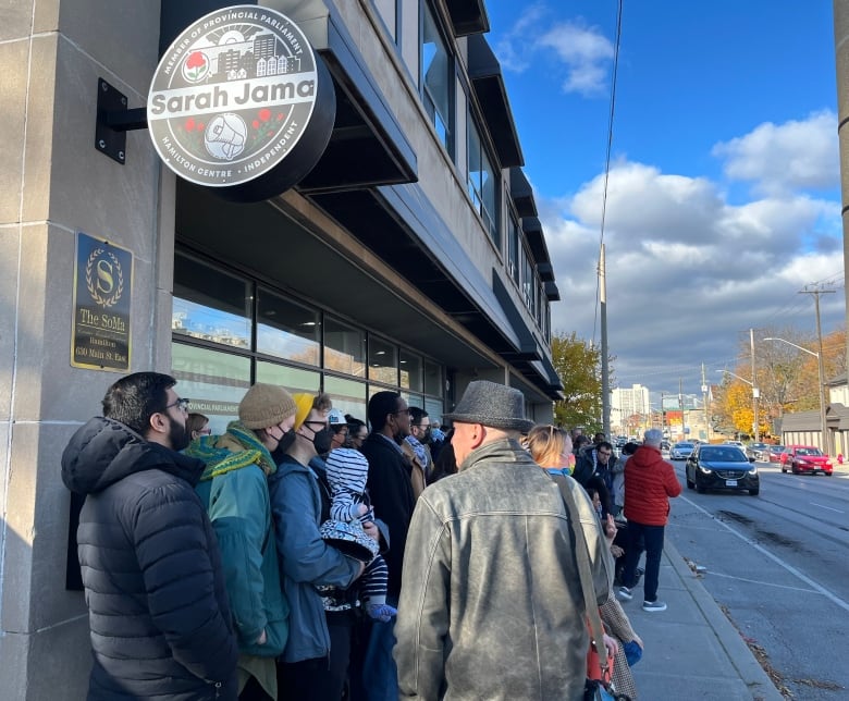 A group of people stand outside a building.