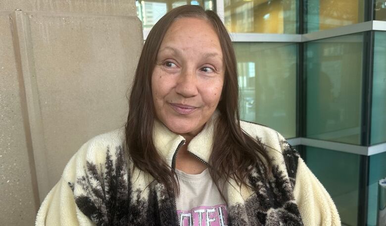 A woman stands in the lobby of the Calgary courthouse. 