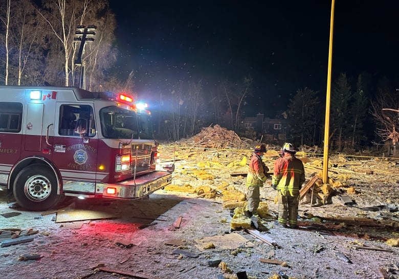 firefighters near a pile of debris