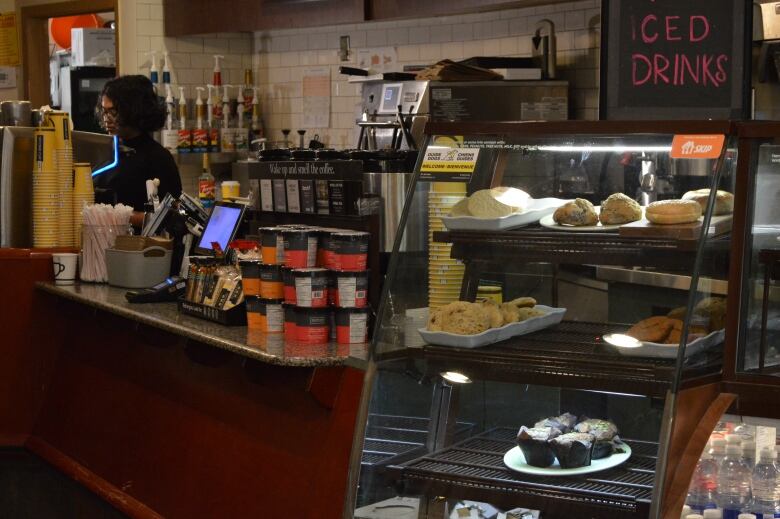 A woman behind coffee counter